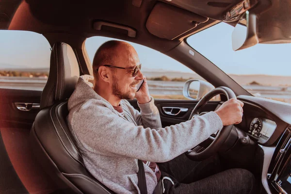 Een Man Met Een Zonnebril Rijdt Een Auto Praat Smartphone — Stockfoto
