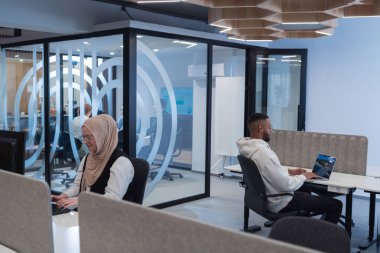 Modern bir ofis ortamında, Afrikalı bir Amerikalı işadamı ve onun Müslüman meslektaşı, tesettür takıyor, işbirlikçi tartışmalara girişiyor, çeşitli iş görevlerini ele alıyor ve sorunları çözüyorlar.