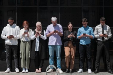 Çeşitli ve kendinden emin iş adamlarından oluşan bir grup, birlikte pozlar vererek, başarı, hırs ve birlik saçarak, dinamik ve ilham verici bir iş ortamının özünü yakalıyorlar.. 