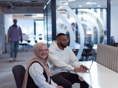 Modern bir ofis ortamında, Afrikalı bir Amerikalı işadamı ve onun Müslüman meslektaşı, tesettür takıyor, işbirlikçi tartışmalara girişiyor, çeşitli iş görevlerini ele alıyor ve sorunları çözüyorlar.