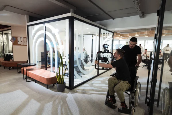 Modern bir ofiste, profesyonel bir videograf ekibi, bir grup genç girişimciyi filme çekerken yaratıcılığın ve yeniliğin özünü yakalar ve işbirliğini ve hırsını sembolize eder.