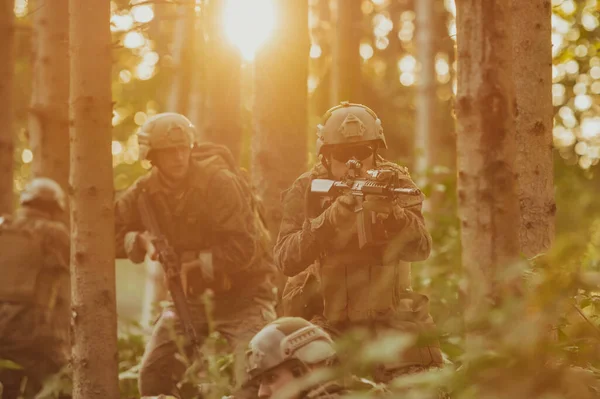現代の戦争兵士のグループは危険な人里離れた森林地帯で戦争を戦っています 現代の武器で敵陣で戦っている兵士のグループ 戦争と軍事の概念 — ストック写真