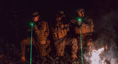 Askerler gece görevinde lazer ışını ışını kullanarak hareket halindeler. Askeri ekip kavramı..