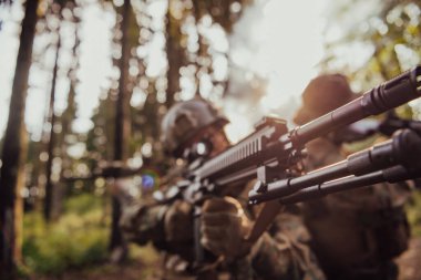 Bir grup modern savaş askeri tehlikeli uzak orman bölgelerinde savaşıyor. Bir grup asker modern silahlarla düşman hattında savaşıyor. Savaş ve askerlik kavramı.