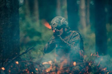 Ateşle çevrili bir savaş ormanında bir asker savaşıyor..
