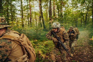 Bir grup modern savaş askeri tehlikeli uzak orman bölgelerinde savaşıyor. Bir grup asker modern silahlarla düşman hattında savaşıyor. Savaş ve askerlik kavramı.