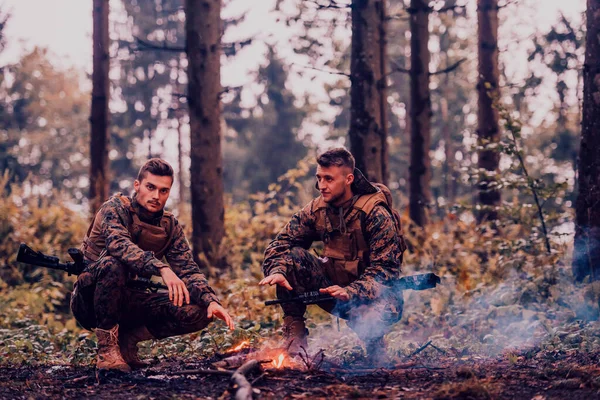 Двоє Виснажених Солдатів Сидять Біля Вогню Після Зношеної Важкої Війни — стокове фото
