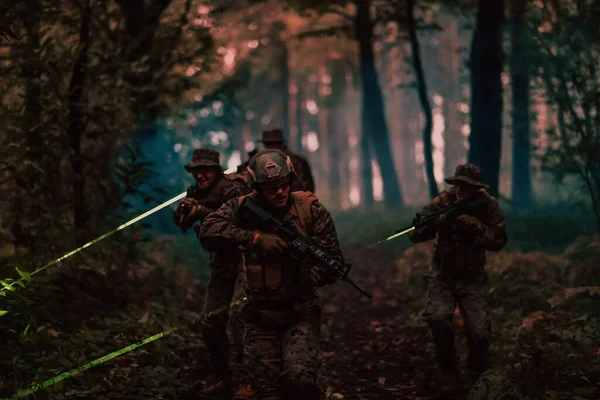 レーザー サイト ビームで夜間任務に従事する兵士部隊は軍のチームコンセプトを照らす — ストック写真