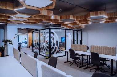 Bir grup genç girişimci odaklanmış bir toplantıya katılıyor, çeşitli iş stratejilerini tartışıyor ve işbirliği içinde zorlu sorunları çözüyorlar, hırslarını, yaratıcılıklarını ve