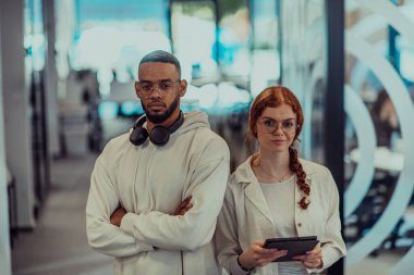 Modern bir ofiste, Afro-Amerikalı genç işadamı ve onun iş kadını meslektaşı, çarpıcı turuncu saçlarıyla, işbirlikçi problem çözme seanslarına katılırlar.. 