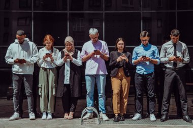 Çeşitli ve kendinden emin iş adamlarından oluşan bir grup, birlikte pozlar vererek, başarı, hırs ve birlik saçarak, dinamik ve ilham verici bir iş ortamının özünü yakalıyorlar.. 