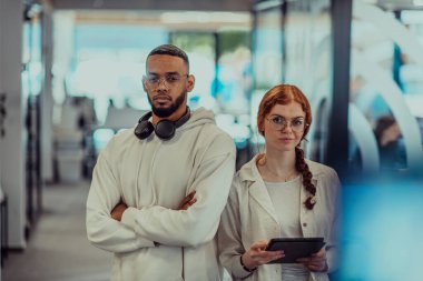 Modern bir ofiste, Afro-Amerikalı genç işadamı ve onun iş kadını meslektaşı, çarpıcı turuncu saçlarıyla, işbirlikçi problem çözme seanslarına katılırlar.. 