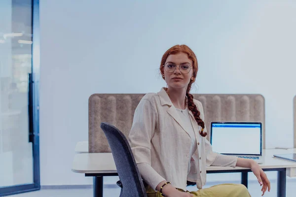 Modern Businesswoman Striking Orange Hair Sitting Confidently Contemporary Office Accompanied — Stock Photo, Image