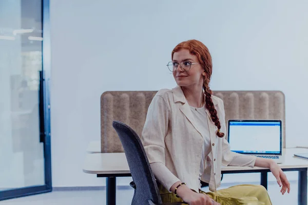 Modern Businesswoman Striking Orange Hair Sitting Confidently Contemporary Office Accompanied — Stock Photo, Image
