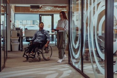 Young business colleagues, collaborative business colleagues, including a person in a wheelchair, walk past a modern glass office corridor, illustrating diversity, teamwork and empowerment in the clipart