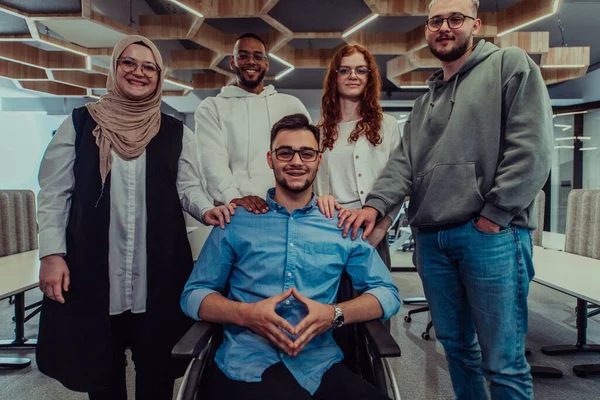 Młodzi Biznesmeni Nowoczesnym Biurze Wyciągają Dłoń Kolegi Biznesowego Wózku Inwalidzkim — Zdjęcie stockowe
