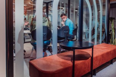 Bir grup genç girişimci odaklanmış bir toplantıya katılıyor, çeşitli iş stratejilerini tartışıyor ve işbirliği içinde zorlu sorunları çözüyorlar, hırslarını, yaratıcılıklarını ve