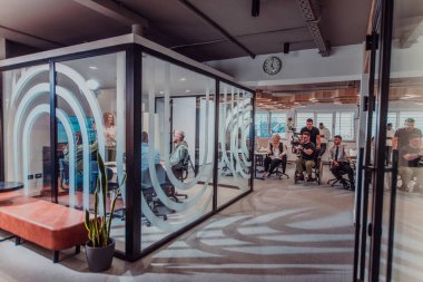 Modern bir ofiste, profesyonel bir videograf ekibi, bir grup genç girişimciyi filme çekerken yaratıcılığın ve yeniliğin özünü yakalar ve işbirliğini ve hırsını sembolize eder.