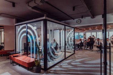 Modern bir ofiste, profesyonel bir videograf ekibi, bir grup genç girişimciyi filme çekerken yaratıcılığın ve yeniliğin özünü yakalar ve işbirliğini ve hırsını sembolize eder.