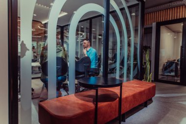 Bir grup genç girişimci odaklanmış bir toplantıya katılıyor, çeşitli iş stratejilerini tartışıyor ve işbirliği içinde zorlu sorunları çözüyorlar, hırslarını, yaratıcılıklarını ve