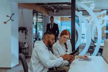 Modern bir ofis ortamında, Afrikalı bir Amerikalı işadamı ve onun Müslüman meslektaşı, tesettür takıyor, işbirlikçi tartışmalara girişiyor, çeşitli iş görevlerini ele alıyor ve sorunları çözüyorlar.