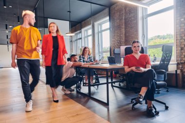 Çeşitli iş adamları, cep telefonları ve bilgisayarlar gibi kağıt tabanlı ve teknolojik araçların bir karışımını toplu olarak kullanmak suretiyle, modern bir ortak çalışma merkezinde işbirliği yapmaktadır.