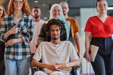 Genç iş adamlarından oluşan çeşitli bir grup, modern bir girişim olan cam kaplı bir ofiste, tekerlekli sandalyedeki bir kişi, bir Afrikalı Amerikalı genç adam ve bir tesettür ile bir araya geliyor.