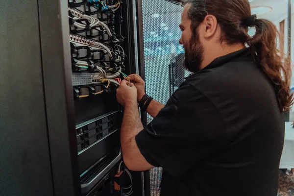 Close up of technician setting up network in server room .