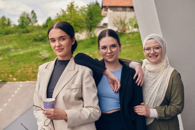 Bir grup profesyonel iş kadını ara veriyor, kahvelerini yudumluyor ve tartışmalara girişiyor, modern işyerinde bir güç ve işbirliği hissi yaratıyor.