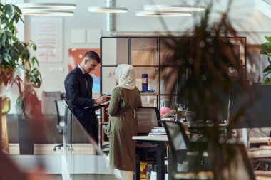 Modern bir başlangıç bürosunun yenilikçi ortamında, yönetmen tesettür takan bir iş kadınıyla tartışır, içerikli diyalog, güç ve dinamik doğayı gösterir.