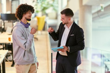 Modern bir ofis ortamında, Afrikalı bir Amerikalı işadamı ve yönetmeni güven içinde ellerini uzatarak bir iş sorununun başarılı bir şekilde çözülmesini sembolize ediyorlar.