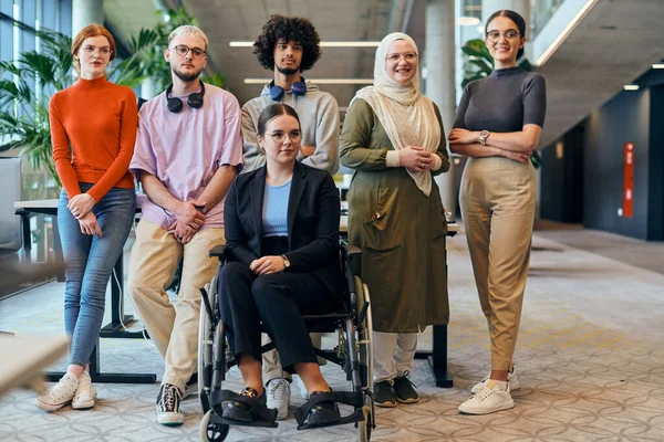 広々としたモダンなスタートアップオフィスでは 車椅子の同僚を含む多様なビジネス同僚が協力し 相互作用し 包括性 多様性 チームワークを例示しています — ストック写真