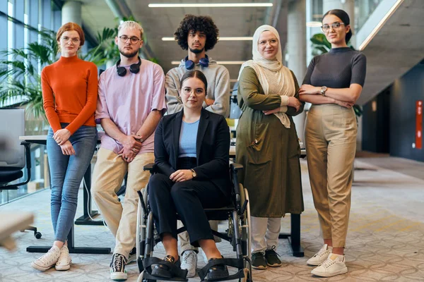 広々としたモダンなスタートアップオフィスでは 車椅子の同僚を含む多様なビジネス同僚が協力し 相互作用し 包括性 多様性 チームワークを例示しています — ストック写真
