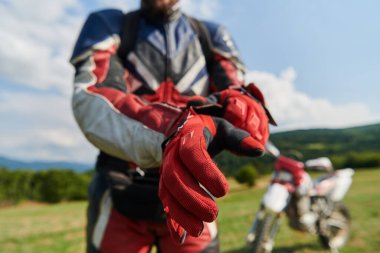 Profesyonel bir motokros sürücüsü eldivenlerini takıp profesyonel bir motokrosa hazırlanıyor.. 