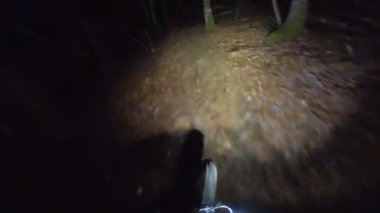 Bir grup arkadaş kış gecesi kaygan bir patikada yokuş aşağı dağ bisikleti sürerken birinci şahıs bakış açısıyla POV göğüs sabit video montajı taze karla birlikte..