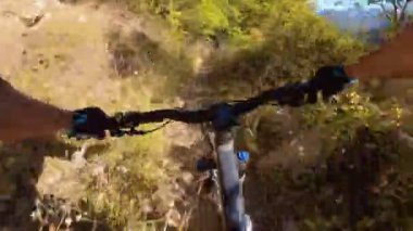 Bir grup arkadaş kayalık bir yolda dağ bisikleti sürerken birinci şahıs bakış açısıyla POV 360 derece sabit göğüs videosu izleyerek kayalık bir yolda hız yapıyorlar..