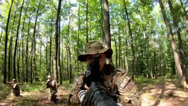 軍事行動中に森の中を移動しながら銃を目指すPovクローズアップの兵士集団 森のカモフラージュユニフォームに装備された戦闘機の部隊 戦術的攻撃の概念 — ストック動画