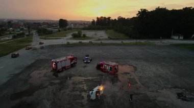 Profesyonel itfaiyecilerden oluşan bir grup hava aracı ekipmanları ve itfaiye aracıyla yangını söndürmek için birlikte çalışıyor. Cesaretlerini ve kahramanlıklarını sergiliyorlar.. 
