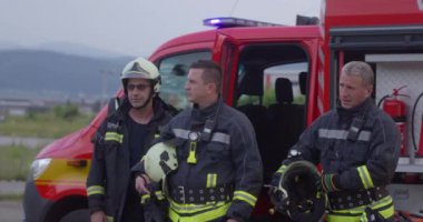 İtfaiyeci ekibi, arka plandaki itfaiye aracı ve itfaiye ekibinin başarılı kurtarma operasyonunun portresi.. 