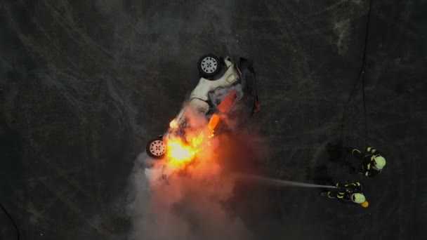 一组专业消防员一起使用他们的设备和消防车扑灭一场汽车火灾的无人驾驶飞机镜头 展示了他们的勇气和英勇努力 — 图库视频影像