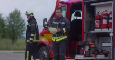 İtfaiyeci ekibi, arka plandaki itfaiye aracı ve itfaiye ekibinin başarılı kurtarma operasyonunun portresi.. 