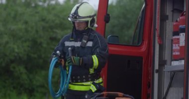 İtfaiyeci ya da itfaiyeci, istasyondaki eğitim sırasında yangın söndürme borusundan su sıkmak için antrenman yapıyor. Felaketleri önlemek için güvenlik uygulaması kavramı. Yüksek kalite 4k