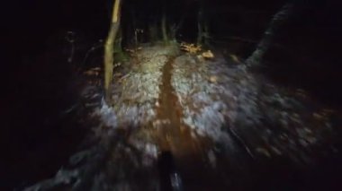 Bir grup arkadaş kış gecesi kaygan bir patikada yokuş aşağı dağ bisikleti sürerken birinci şahıs bakış açısıyla POV göğüs sabit video montajı taze karla birlikte..