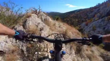 Bir grup arkadaş kayalık bir yolda dağ bisikleti sürerken birinci şahıs bakış açısıyla POV 360 derece sabit göğüs videosu izleyerek kayalık bir yolda hız yapıyorlar..