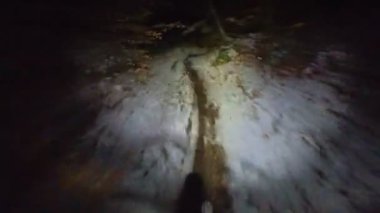 Bir grup arkadaş kış gecesi kaygan bir patikada yokuş aşağı dağ bisikleti sürerken birinci şahıs bakış açısıyla POV göğüs sabit video montajı taze karla birlikte..