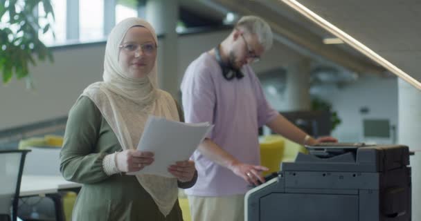 스타트업 사무실에서 히잡을 착용하는 비즈니스 중심의 이슬람 여성은 동료와 협력하여 — 비디오