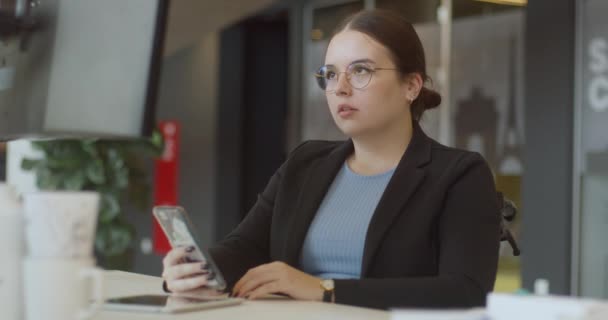 Eine Enttäuschte Frau Rollstuhl Die Ihr Smartphone Einem Modernen Büro — Stockvideo