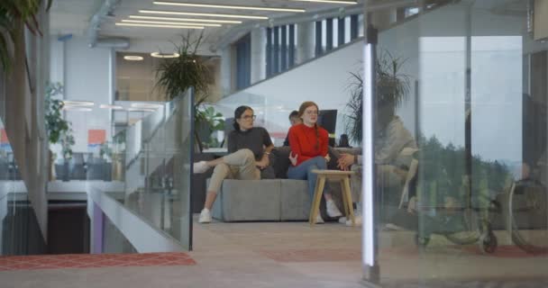 一位坐在现代公司轮椅上的女商人和她的同事在后面讨论着 这象征着一个重视包容性 多样性和合作性讨论的工作场所 — 图库视频影像