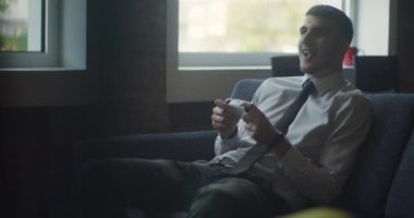 Bir işletme müdürü, modern bir ofiste işe ara verir ve oyun oynamaya başlar. Bir kumandayla TV 'de oyun oynar. Boş vakitleri ve rahatlığı bir tutam ofis ile birleştirir.