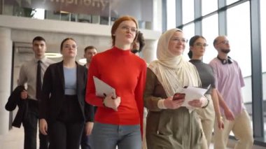 Modern bir girişim ofisinin gösterişli koridorlarında, yönetmenleri tarafından yönetilen çeşitli meslektaşlar, kolektif başarıyı ve yeni iş yolculuğunu sembolize ederek güvenli bir şekilde ileriye doğru adım atıyorlar.